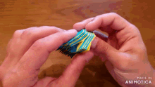 a person is holding a blue and yellow object in their hands ..