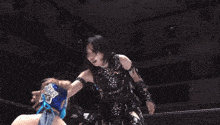 a female wrestler wearing a blue mask talks to a man