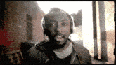 a man wearing headphones looks at the camera with his mouth open
