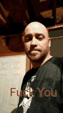 a man wearing a black shirt that says " fuck you "