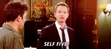 a man in a suit and tie is standing next to another man and says self five