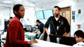 a man and woman are talking in a hospital room with a sign that says 7 on it