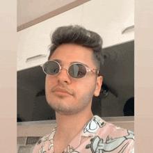 a young man wearing sunglasses and a shirt with a cartoon on it