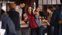 a woman talking on a cell phone while holding wine glasses
