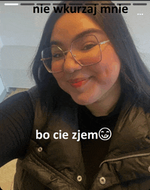 a woman wearing glasses and a black vest with the words bo cie zjem written on the bottom
