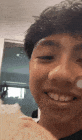 a young man is smiling while holding a piece of rice in his hand