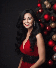 a woman in a white dress stands in front of christmas decorations