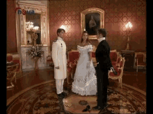 a woman in a white dress is standing in a room with a man in a suit
