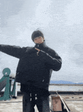 a man wearing a black jacket is standing on a roof