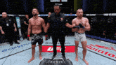 a referee stands between two fighters in a boxing ring