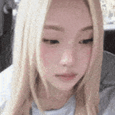 a close up of a woman 's face with long blonde hair and pink cheeks .