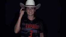 a man wearing a campbell jersey holds a cowboy hat over his face