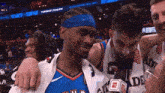 a basketball player wearing a headband with the letter e on it is surrounded by other players