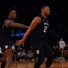 a basketball player with the number 21 on his jersey is running on the court