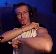 a man with glasses and headphones is flexing his muscles