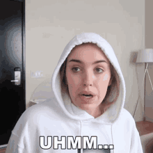 a woman wearing a white hoodie says uhm