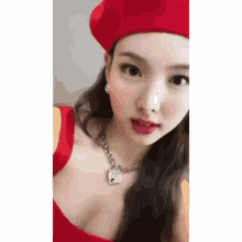 a close up of a woman wearing a red beret and a red top .