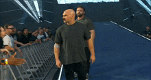 two men walking down a blue aisle with a sign in the background that says ' let 's go '