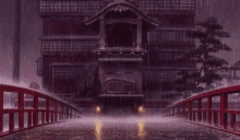 a bridge over a body of water in front of a building in the rain .
