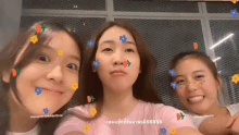 three young women are posing for a picture with flowers on their faces .