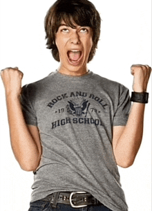 a young man wearing a grey rock and roll high school shirt