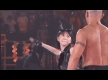 a man and a woman are standing next to each other in a ring . the woman has horns on her head .
