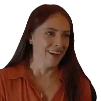 a woman wearing a red shirt and a gold necklace is smiling