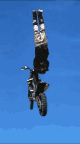 a person is doing a trick on a dirt bike that says ' suzuki ' on the front