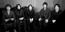 a black and white photo of a group of young men in suits