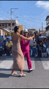 a man and a woman are dancing in front of a crowd .