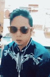 a man wearing sunglasses and ear buds is looking at the camera