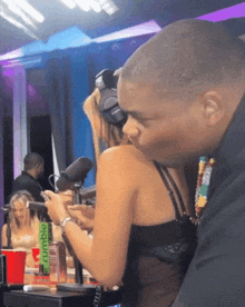 a man kisses a woman in front of a green tumbler that says " rumble "