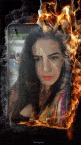 a woman 's face is surrounded by fire and the letter a is on the screen
