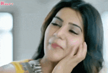 a close up of a woman 's face with her hand on her chin