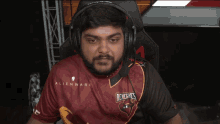 a man wearing headphones and an alienware renegades shirt