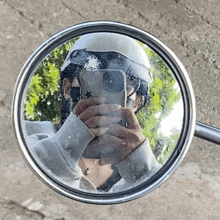 a person is taking a picture of themselves in a rear view mirror