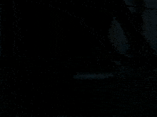 a man standing in a dark room with a sword in his hand