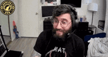 a man with a beard wearing headphones and a rat shirt
