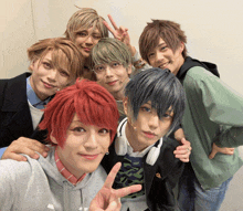 a group of young men are posing for a picture and one of them is wearing headphones on his neck