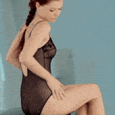 a woman with a tattoo on her back is wearing a black leotard