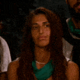 a woman with a green scarf around her neck is looking up