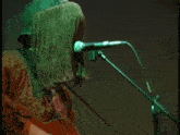 a person with a fringed hat on playing a guitar and singing into a microphone
