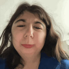a close up of a woman 's face with a blue shirt