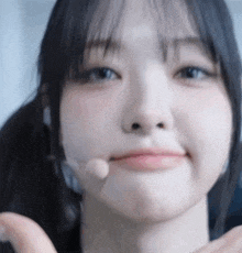 a close up of a girl 's face with a microphone in her mouth
