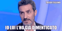 a man with a beard and mustache is talking into a microphone and says trash italiano