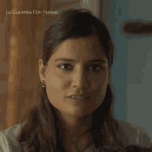 a close up of a woman 's face with la guarimba film festival written on the bottom right
