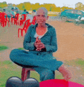 a man is sitting on a red table with his legs crossed and smiling .