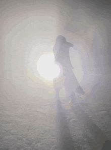 a silhouette of a person standing in front of a bright sun