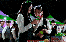 two girls wearing cat ears are playing a game at a carnival ..