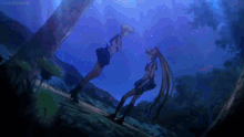 a couple of girls are standing next to each other in a forest at night .